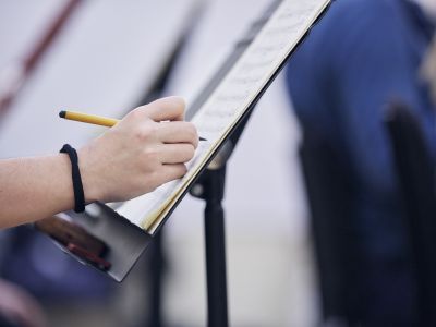 Hand writing notes on sheet music